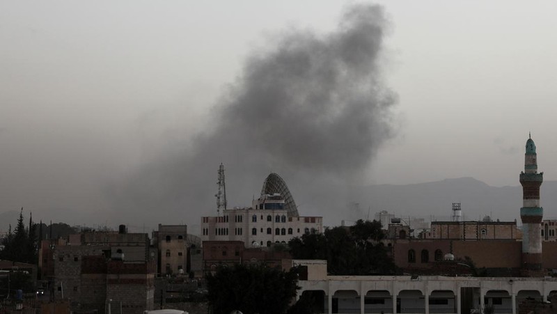 Seorang penjaga keamanan memeriksa lokasi serangan udara koalisi militer pimpinan Arab Saudi di sebuah stasiun telekomunikasi di Sanaa, Yaman, Senin (14/2/2022). (REUTERS/Khaled Abdullah)
