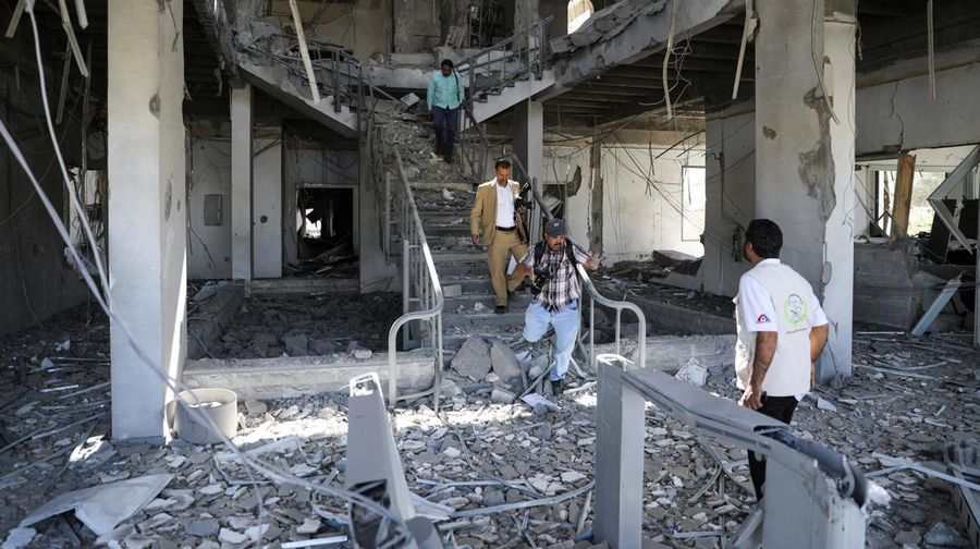 Seorang penjaga keamanan memeriksa lokasi serangan udara koalisi militer pimpinan Arab Saudi di sebuah stasiun telekomunikasi di Sanaa, Yaman, Senin (14/2/2022). (REUTERS/Khaled Abdullah)