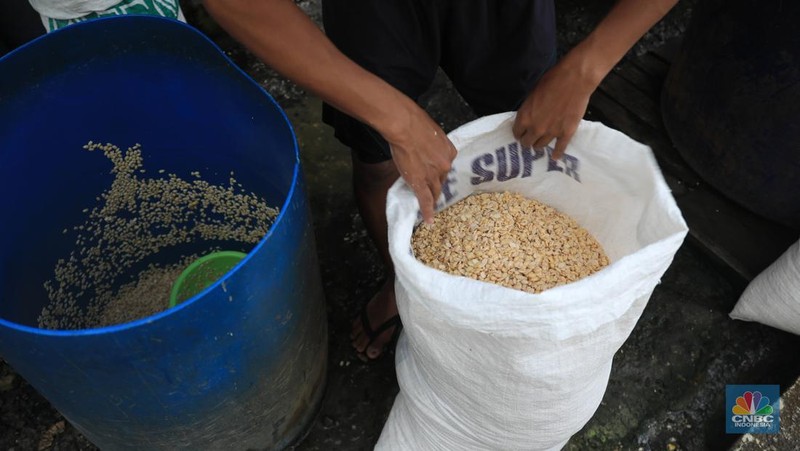 Perajin membuat tempe di industri rumahan skala kecil di Jalan Wahid, Ciputat, Tangerang Selatan, Selasa, (15/2/2022). Kenaikan biaya bahan baku utama itu dilaporkan jadi penyebab berhentinya produksi sejumlah industri rumahan tempe dan tahu (CNBC Indonesia/ Muhammad Sabki