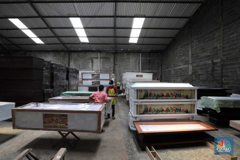 Pekerja menyelesaikan pembuatan peti jenazah di kawasan Daanmogot, Jurumudi Baru, Tangerang, Banten, Selasa (15/2/2022). Meningkatknya  kasus Covid-19 di Jakarta dan beberapa daerah membuat pesanan pembuatan peti mati naik 30 persen mulai dari Januari 2022 hingga sekarang.  (CNBC Indonesia/ Tri Susilo)