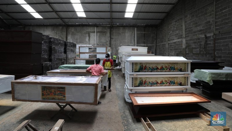 Pekerja menyelesaikan pembuatan peti jenazah di kawasan Daanmogot, Jurumudi Baru, Tangerang, Banten, Selasa (15/2/2022). Meningkatknya  kasus Covid-19 di Jakarta dan beberapa daerah membuat pesanan pembuatan peti mati naik 30 persen mulai dari Januari 2022 hingga sekarang.  (CNBC Indonesia/ Tri Susilo)