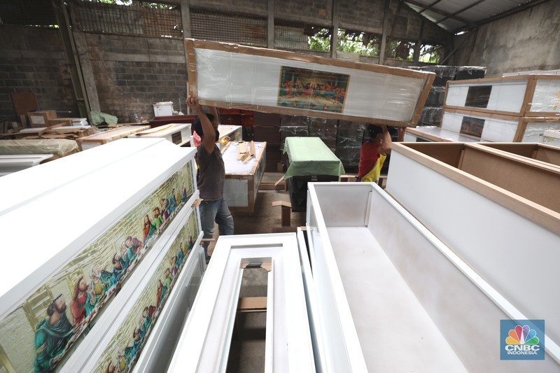 Pekerja menyelesaikan pembuatan peti jenazah di kawasan Daanmogot, Jurumudi Baru, Tangerang Pekerja menyelesaikan pembuatan peti jenazah di kawasan Daanmogot, Jurumudi Baru, Tangerang, Banten, Selasa (15/2/2022). Meningkatknya kasus Covid-19 di Jakarta dan beberapa daerah membuat pesanan pembuatan peti mati naik 30 persen mulai dari Januari 2022 hingga sekarang. (CNBC Indonesia/ Tri Susilo)
