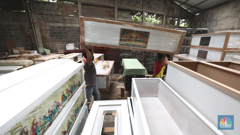 Pekerja menyelesaikan pembuatan peti jenazah di kawasan Daanmogot, Jurumudi Baru, Tangerang, Banten, Selasa (15/2/2022). Meningkatknya  kasus Covid-19 di Jakarta dan beberapa daerah membuat pesanan pembuatan peti mati naik 30 persen mulai dari Januari 2022 hingga sekarang.  (CNBC Indonesia/ Tri Susilo)