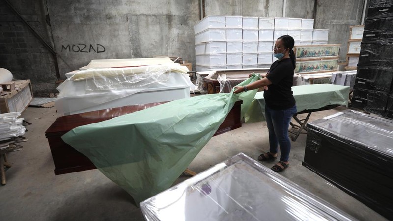 Pekerja menyelesaikan pembuatan peti jenazah di kawasan Daanmogot, Jurumudi Baru, Tangerang, Banten, Selasa (15/2/2022). Meningkatknya  kasus Covid-19 di Jakarta dan beberapa daerah membuat pesanan pembuatan peti mati naik 30 persen mulai dari Januari 2022 hingga sekarang.  (CNBC Indonesia/ Tri Susilo)