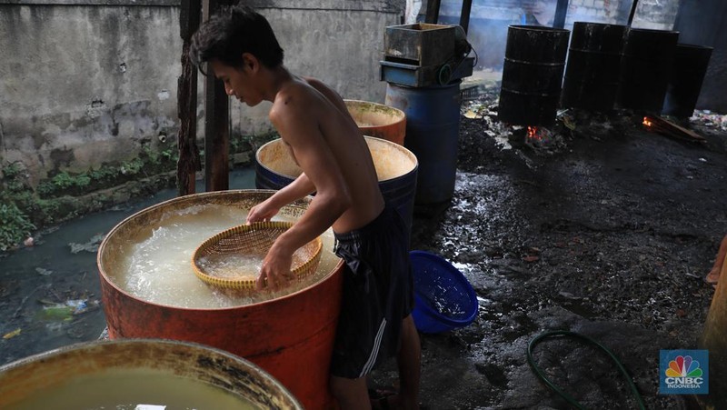 Perajin membuat tempe di industri rumahan skala kecil di Jalan Wahid, Ciputat, Tangerang Selatan, Selasa, (15/2/2022). Kenaikan biaya bahan baku utama itu dilaporkan jadi penyebab berhentinya produksi sejumlah industri rumahan tempe dan tahu (CNBC Indonesia/ Muhammad Sabki