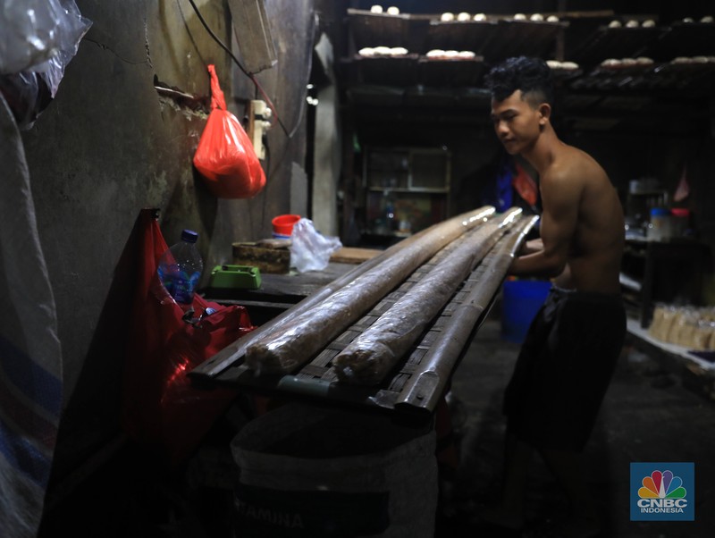 Perajin membuat tempe di industri rumahan skala kecil di Jalan Wahid, Ciputat, Tangerang Selatan, Selasa, (15/2/2022). Kenaikan biaya bahan baku utama itu dilaporkan jadi penyebab berhentinya produksi sejumlah industri rumahan tempe dan tahu (CNBC Indonesia/ Muhammad Sabki