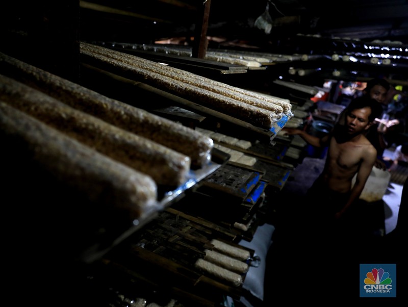Perajin membuat tempe di industri rumahan skala kecil di Jalan Wahid, Ciputat, Tangerang Selatan, Selasa, (15/2/2022). Kenaikan biaya bahan baku utama itu dilaporkan jadi penyebab berhentinya produksi sejumlah industri rumahan tempe dan tahu (CNBC Indonesia/ Muhammad Sabki