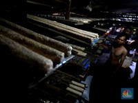 Perajin membuat tempe di industri rumahan skala kecil di Jalan Wahid, Ciputat, Tangerang Selatan, Selasa, (15/2/2022). Kenaikan biaya bahan baku utama itu dilaporkan jadi penyebab berhentinya produksi sejumlah industri rumahan tempe dan tahu (CNBC In