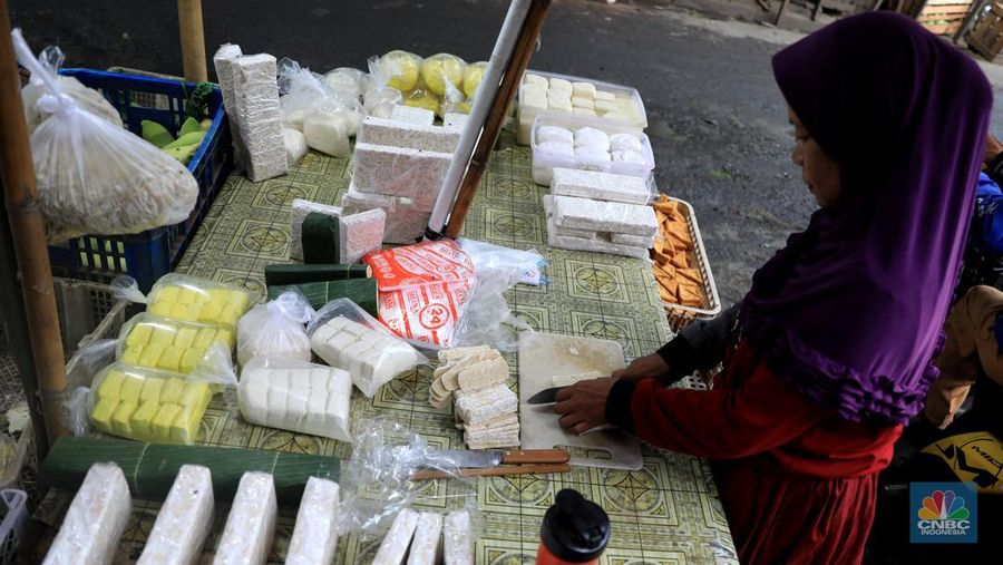 Perajin membuat tempe di industri rumahan skala kecil di Jalan Wahid, Ciputat, Tangerang Selatan, Selasa, (15/2/2022). Kenaikan biaya bahan baku utama itu dilaporkan jadi penyebab berhentinya produksi sejumlah industri rumahan tempe dan tahu (CNBC Indonesia/ Muhammad Sabki