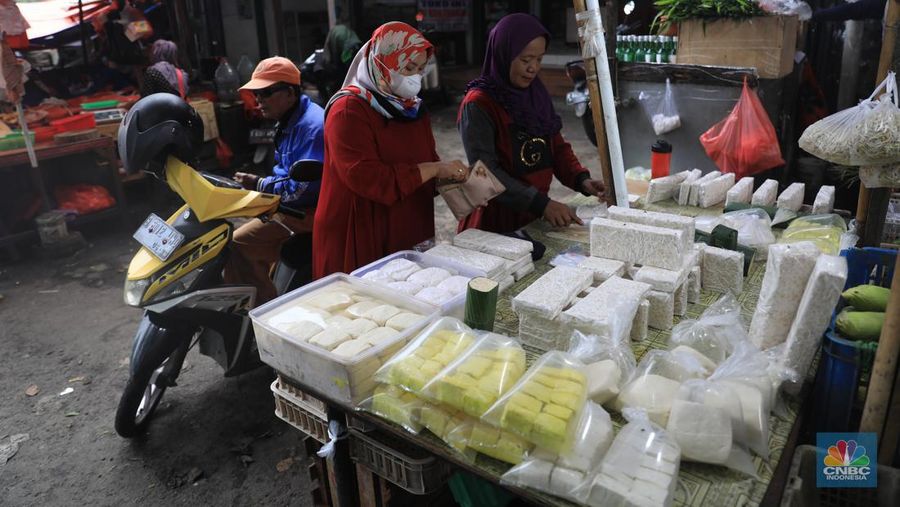 Pedagang tempe melayani pembeli di Pasar Kebayoran Lama, Jakarta, Selasa (15/2/2022). Lonjakan harga kedelai global berdampal bagi industri tempe dan tahu di dalam negeri, yang didominasi skala rumah tangga.(²©²ÊÍøÕ¾/ Muhammad Sabki)