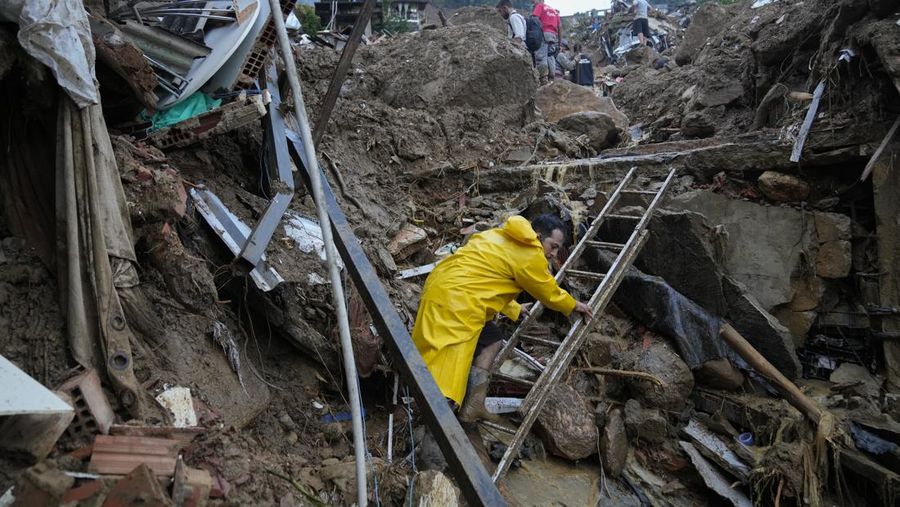Rescue workers and residents search for victims in an area affected by landslides in Petropolis, Brazil, Wednesday, Feb. 16, 2022. Extremely heavy rains set off mudslides and floods in a mountainous region of Rio de Janeiro state, killing multiple people, authorities reported. (AP Photo/Silvia Izquierdo)