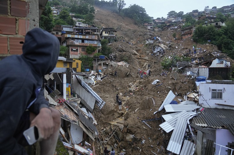 Brazil Deadly Rains Rescue workers and residents search for victims in an area affected by landslides in Petropolis, Brazil, Wednesday, Feb. 16, 2022. Extremely heavy rains set off mudslides and floods in a mountainous region of Rio de Janeiro state, killing multiple people, authorities reported. (AP Photo/Silvia Izquierdo)