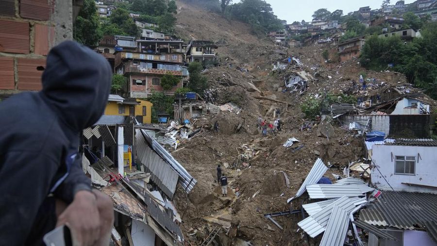 Rescue workers and residents search for victims in an area affected by landslides in Petropolis, Brazil, Wednesday, Feb. 16, 2022. Extremely heavy rains set off mudslides and floods in a mountainous region of Rio de Janeiro state, killing multiple people, authorities reported. (AP Photo/Silvia Izquierdo)