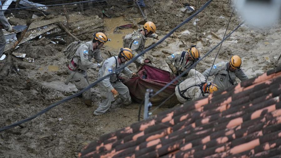 Rescue workers and residents search for victims in an area affected by landslides in Petropolis, Brazil, Wednesday, Feb. 16, 2022. Extremely heavy rains set off mudslides and floods in a mountainous region of Rio de Janeiro state, killing multiple people, authorities reported. (AP Photo/Silvia Izquierdo)