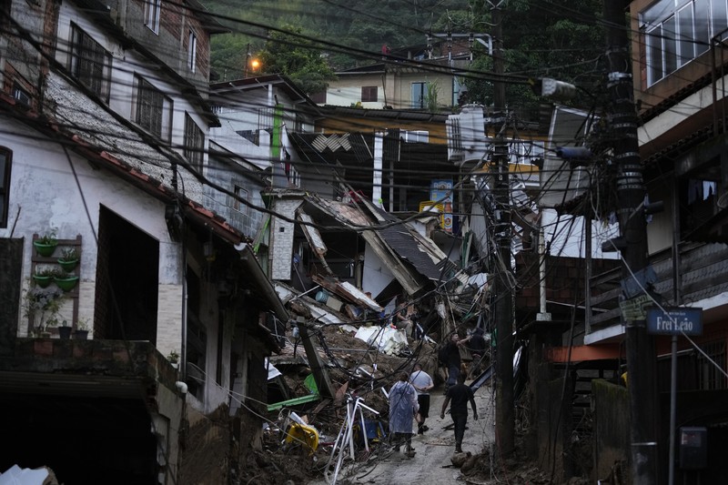 Brazil Deadly Rains Rescue workers and residents search for victims in an area affected by landslides in Petropolis, Brazil, Wednesday, Feb. 16, 2022. Extremely heavy rains set off mudslides and floods in a mountainous region of Rio de Janeiro state, killing multiple people, authorities reported. (AP Photo/Silvia Izquierdo)