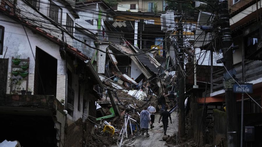 Rescue workers and residents search for victims in an area affected by landslides in Petropolis, Brazil, Wednesday, Feb. 16, 2022. Extremely heavy rains set off mudslides and floods in a mountainous region of Rio de Janeiro state, killing multiple people, authorities reported. (AP Photo/Silvia Izquierdo)