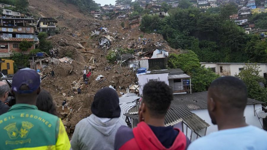 Rescue workers and residents search for victims in an area affected by landslides in Petropolis, Brazil, Wednesday, Feb. 16, 2022. Extremely heavy rains set off mudslides and floods in a mountainous region of Rio de Janeiro state, killing multiple people, authorities reported. (AP Photo/Silvia Izquierdo)