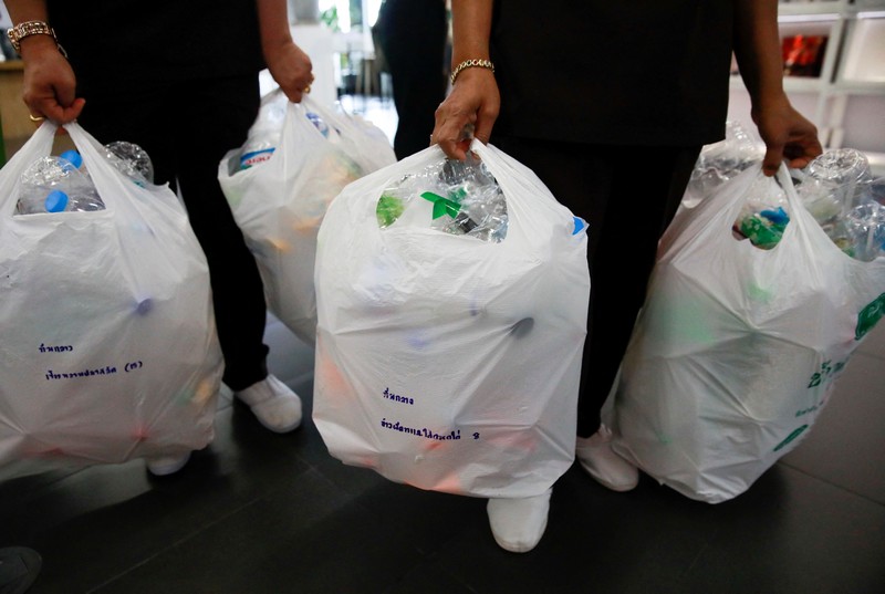 THAILAND-ENVIRONMENT/PLASTIC-AMULETS A woman shows an amulet, above 1kg of plastic bottles, which was made from 1kg of trash such as plastic bags, bottle caps, milk cotton and fishing nets, at Bangkok Design Week festival, in Bangkok, Thailand January 12, 2022. Picture taken January 12, 2022. REUTERS/Soe Zeya Tun