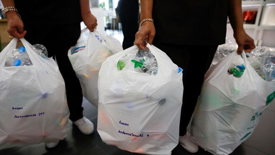A woman shows an amulet, above 1kg of plastic bottles, which was made from 1kg of trash such as plastic bags, bottle caps, milk cotton and fishing nets, at Bangkok Design Week festival, in Bangkok, Thailand January 12, 2022. Picture taken January 12, 2022. REUTERS/Soe Zeya Tun