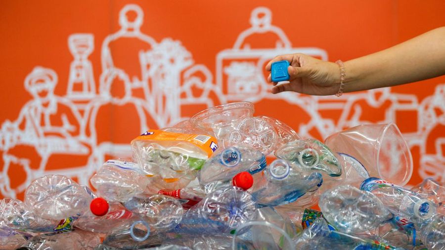 A woman shows an amulet, above 1kg of plastic bottles, which was made from 1kg of trash such as plastic bags, bottle caps, milk cotton and fishing nets, at Bangkok Design Week festival, in Bangkok, Thailand January 12, 2022. Picture taken January 12, 2022. REUTERS/Soe Zeya Tun