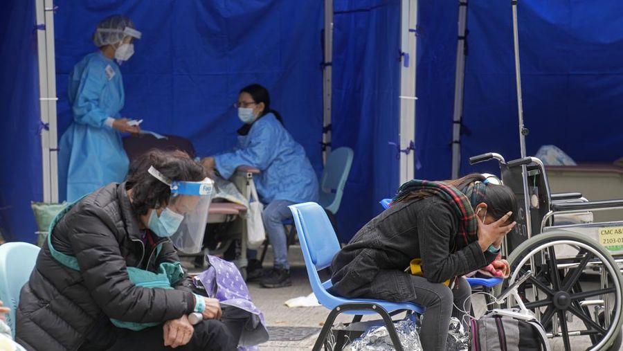 People, including current hospital patients, showing COVID-19 symptoms wait at a temporary holding area outside Caritas Medical Centre in Hong Kong Wednesday, Feb. 16, 2022. China's leader Xi Jinping took a personal interest in Hong Kong's outbreak, saying it was the local government's