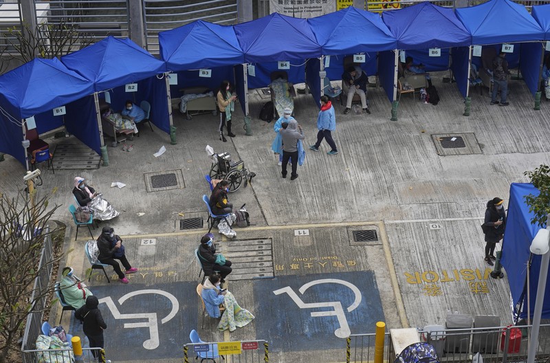 Virus Outbreak Hong Kong Patients lie on hospital beds as they wait at a temporary holding area outside Caritas Medical Centre in Hong Kong Wednesday, Feb.16, 2022. There was visible evidence that Hong Kong hospitals were becoming overwhelmed by the latest COVID surge, with patients on stretchers and in tents being seen to by medical personnel on Wednesday outside the Caritas hospital. (AP Photo Vincent Yu)
