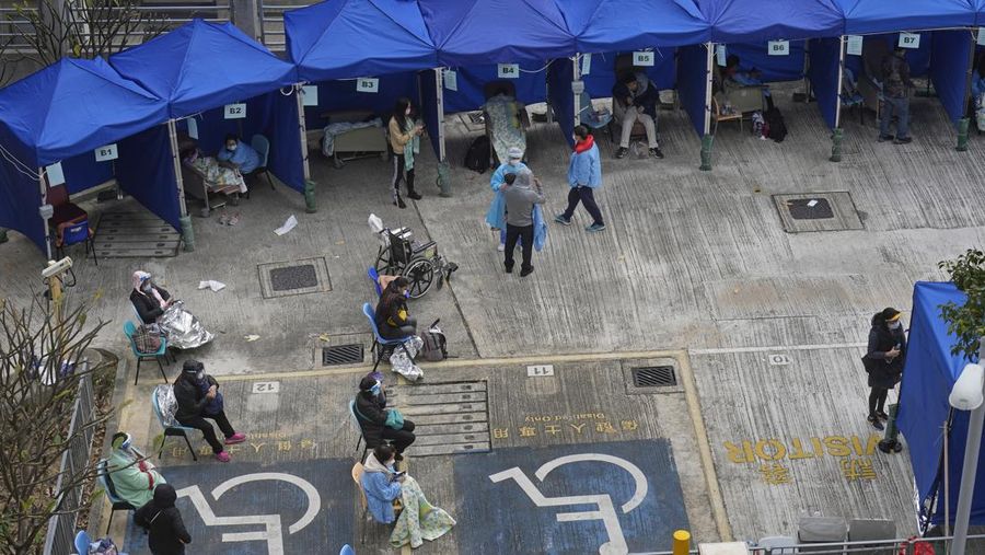 People, including current hospital patients, showing COVID-19 symptoms wait at a temporary holding area outside Caritas Medical Centre in Hong Kong Wednesday, Feb. 16, 2022. China's leader Xi Jinping took a personal interest in Hong Kong's outbreak, saying it was the local government's 