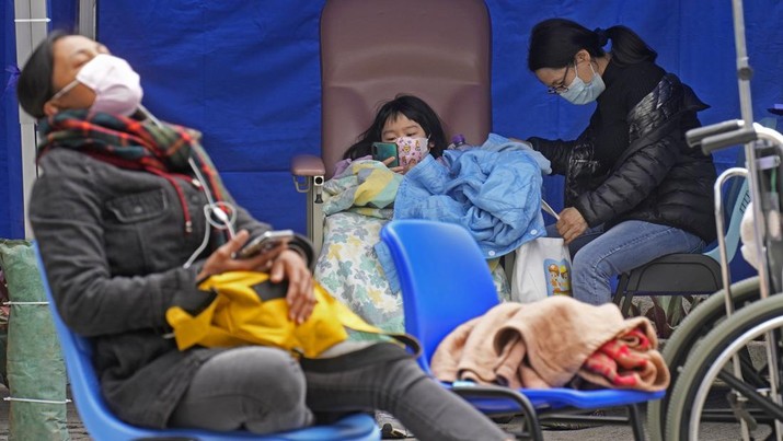 People, including current hospital patients, showing COVID-19 symptoms wait at a temporary holding area outside Caritas Medical Centre in Hong Kong Wednesday, Feb. 16, 2022. China's leader Xi Jinping took a personal interest in Hong Kong's outbreak, saying it was the local government's 