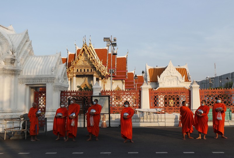 A motor-tricycle, or Tuk Tuk drives past Grand Palace in Bangkok, Thailand on Aug. 3, 2021. As Thailand battles a punishing COVID-19 surge with nearly 20,000 new cases every day, people who depend on tourism struggle in what was one of the most-visited cities in the world, with 20 million visitors in the year before the pandemic. (AP Photo/Sakchai Lalit)