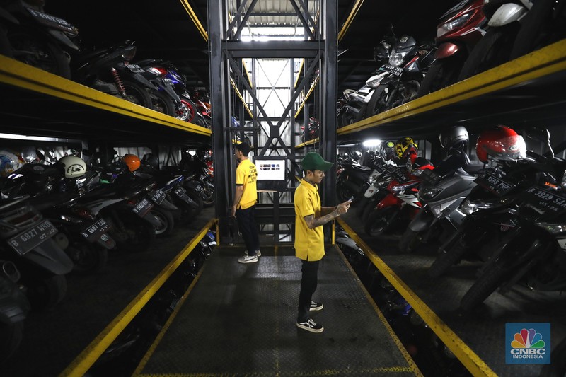 Warga memakirkan motornya di tempat parkir dengan menggunakan sistem parkir susun dengan lift barang di Soul Parking, dikawasan Jakarta, Kamis (17/2/2022). Sistem  parkir susun dengan lift barang  merupakan solusi dalam keterbatasan lahan parkir. (CNBC Indonesia/ Tri Susilo)