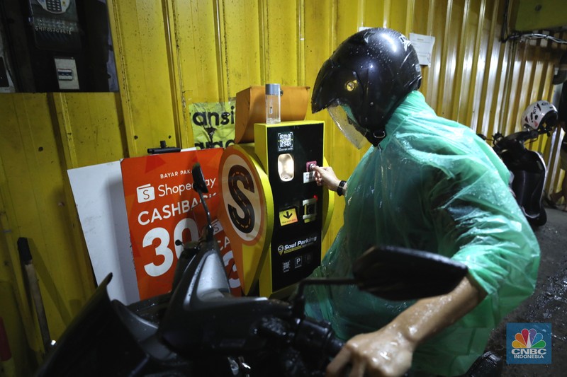 Warga memakirkan motornya di tempat parkir dengan menggunakan sistem parkir susun dengan lift barang di Soul Parking, dikawasan Jakarta, Kamis (17/2/2022). Sistem  parkir susun dengan lift barang  merupakan solusi dalam keterbatasan lahan parkir. (CNBC Indonesia/ Tri Susilo)