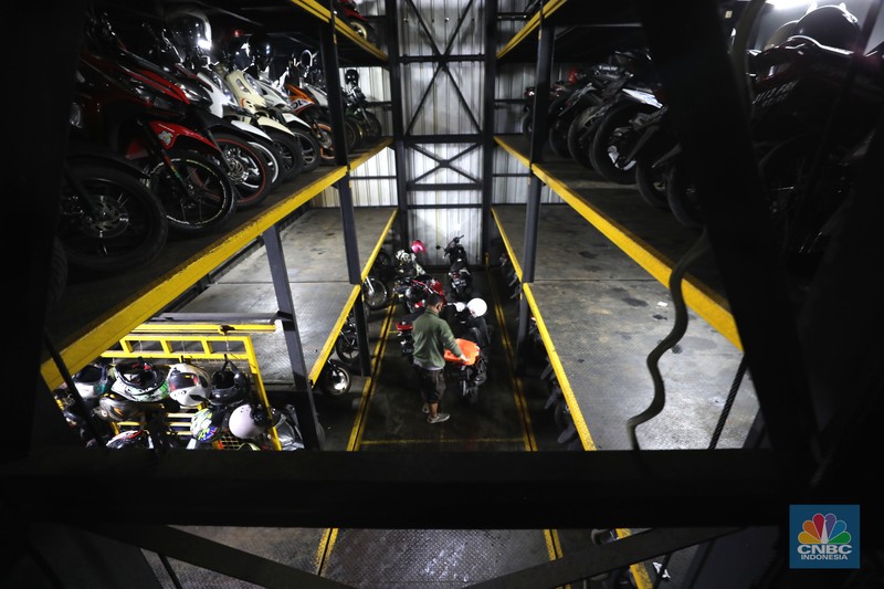 Warga memakirkan motornya di tempat parkir dengan menggunakan sistem parkir susun dengan lift barang di Soul Parking, dikawasan Jakarta, Kamis (17/2/2022). Sistem  parkir susun dengan lift barang  merupakan solusi dalam keterbatasan lahan parkir. (CNBC Indonesia/ Tri Susilo)