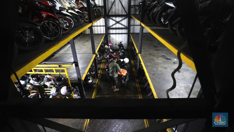 Warga memakirkan motornya di tempat parkir dengan menggunakan sistem parkir susun dengan lift barang di Soul Parking, dikawasan Jakarta, Kamis (17/2/2022). Sistem  parkir susun dengan lift barang  merupakan solusi dalam keterbatasan lahan parkir. (CNBC Indonesia/ Tri Susilo)