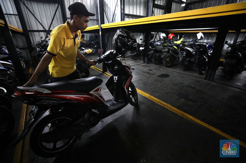 Warga memakirkan motornya di tempat parkir dengan menggunakan sistem parkir susun dengan lift barang di Soul Parking, dikawasan Jakarta, Kamis (17/2/2022). Sistem  parkir susun dengan lift barang  merupakan solusi dalam keterbatasan lahan parkir. (CNBC Indonesia/ Tri Susilo)