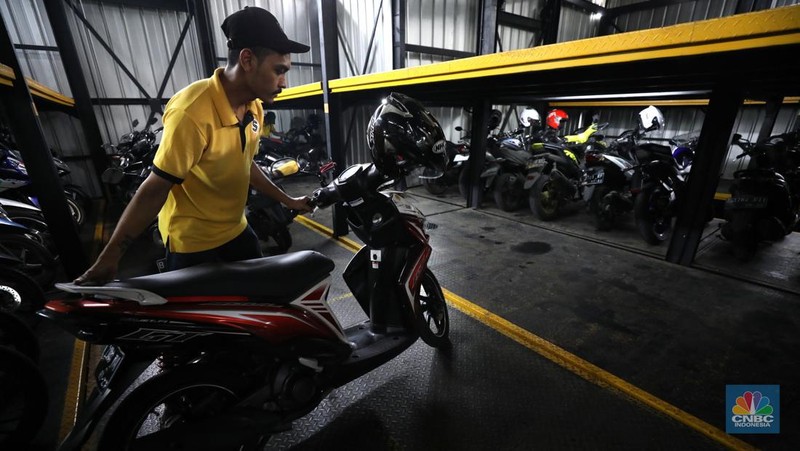 Warga memakirkan motornya di tempat parkir dengan menggunakan sistem parkir susun dengan lift barang di Soul Parking, dikawasan Jakarta, Kamis (17/2/2022). Sistem  parkir susun dengan lift barang  merupakan solusi dalam keterbatasan lahan parkir. (CNBC Indonesia/ Tri Susilo)