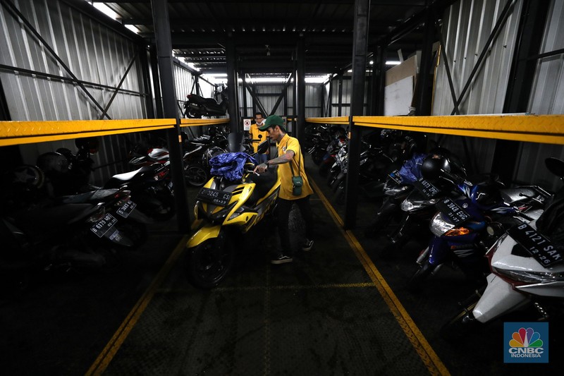 Warga memakirkan motornya di tempat parkir dengan menggunakan sistem parkir susun dengan lift barang di Soul Parking, dikawasan Jakarta, Kamis (17/2/2022). Sistem  parkir susun dengan lift barang  merupakan solusi dalam keterbatasan lahan parkir. (CNBC Indonesia/ Tri Susilo)