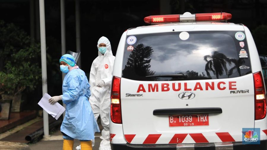 Tenaga medis mengantar pasien dengan ambulance saat tiba di Graha Wisata TMII, Jakarta, Kamis, 17/2. Jakarta jadi salah satu daerah yang mencatatkan kenaikan kasus COVID-19.(CNBC Indonesia/ Muhammad Sabki)