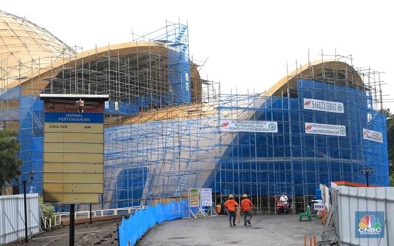 Revitalisasi TMII Pekerja melintas dibawah konstruksi bangunan Teater Keong Emas TMII yang sedang direnovasi di Kawasan TMII, Jakarta, Kamis, 17/2. Pemerintah tengah merenovasi Taman Mini Indonesia Indah (TMII). Direktur Utama In Journey Dony Oskaria, mengatakan renovasi miniatur Indonesia ini ditargetkan selesai pada tahun ini. Dikutip dari berita CNBC Indonesia pada Rabu, 9/2, Direktur Utama In Journey Dony Oskaria, mengatakan renovasi miniatur Indonesia ini ditargetkan selesai pada tahun ini. (CNBC Indonesia/ Muhammad Sabki)