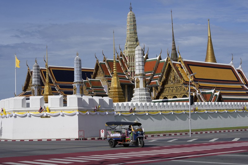 Sebuah Tuk Tuk melewati Grand Palace di Bangkok, Thailand A motor-tricycle, or Tuk Tuk drives past Grand Palace in Bangkok, Thailand on Aug. 3, 2021. As Thailand battles a punishing COVID-19 surge with nearly 20,000 new cases every day, people who depend on tourism struggle in what was one of the most-visited cities in the world, with 20 million visitors in the year before the pandemic. (AP Photo/Sakchai Lalit)