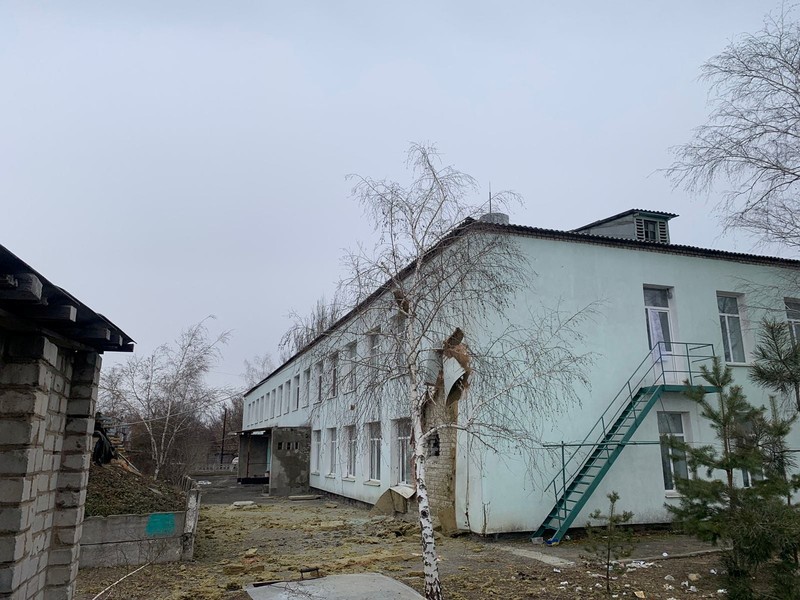 Seorang penduduk setempat berdiri di dekat sebuah lubang di dinding di dalam ruang kelas taman kanak-kanak, yang menurut pejabat militer Ukraina, dirusak oleh penembakan, di Stanytsia Luhanska di wilayah Luhansk, Ukraina, Kamis (17/2/2022). (REUTERS/Carlos Barria)