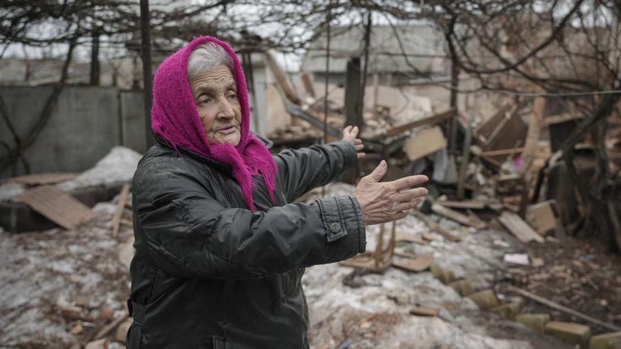 Seorang penduduk setempat berdiri di dekat sebuah lubang di dinding di dalam ruang kelas taman kanak-kanak, yang menurut pejabat militer Ukraina, dirusak oleh penembakan, di Stanytsia Luhanska di wilayah Luhansk, Ukraina, Kamis (17/2/2022). (REUTERS/Carlos Barria)