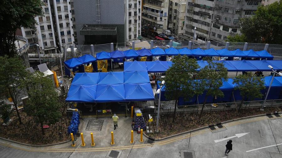 Pasien berbaring di ranjang rumah sakit saat mereka menunggu di area perawatan sementara di luar Caritas Medical Center di Hong Kong, Jumat (18/2/2022). Rumah sakit Hong Kong mencapai kapasitas 90% pada hari Kamis dan fasilitas karantina sudah mencapai batasnya, kata pihak berwenang, ketika kota itu berjuang untuk memadamkan rekor jumlah kasus baru COVID-19. (AP Photo/Kin Cheung)