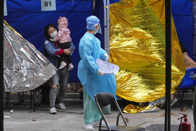 Pasien berbaring di ranjang rumah sakit saat mereka menunggu di area perawatan sementara di luar Caritas Medical Center di Hong Kong, Jumat (18/2/2022). Rumah sakit Hong Kong mencapai kapasitas 90% pada hari Kamis dan fasilitas karantina sudah mencapai batasnya, kata pihak berwenang, ketika kota itu berjuang untuk memadamkan rekor jumlah kasus baru COVID-19. (AP Photo/Kin Cheung)