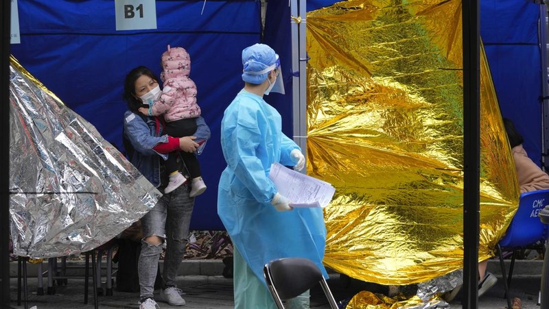 Pasien berbaring di ranjang rumah sakit saat mereka menunggu di area perawatan sementara di luar Caritas Medical Center di Hong Kong, Jumat (18/2/2022). Rumah sakit Hong Kong mencapai kapasitas 90% pada hari Kamis dan fasilitas karantina sudah mencapai batasnya, kata pihak berwenang, ketika kota itu berjuang untuk memadamkan rekor jumlah kasus baru COVID-19. (AP Photo/Kin Cheung)