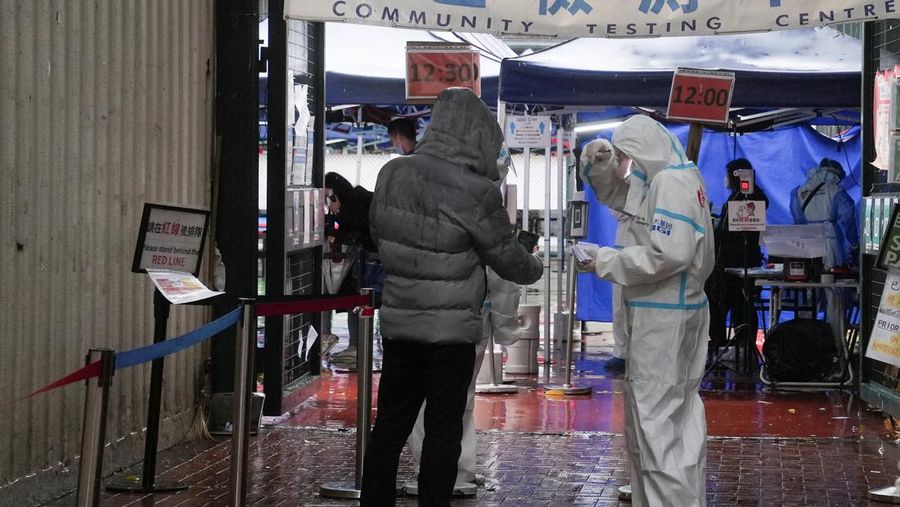 A medical worker wearing personal protective equipment (PPE), speaks with a person outside a community testing centre for the coronavirus disease (COVID-19) following the outbreak in Hong Kong, China February 19, 2022. REUTERS/Lam Yik
