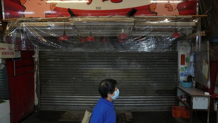 A pedestrian wearing a face mask walks past a closed fresh meat shop inside a wet market, following the coronavirus disease (COVID-19) outbreak in Hong Kong, China February 19, 2022. REUTERS/Lam Yik