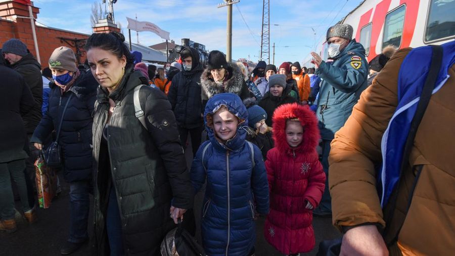 Orang-orang dari wilayah Donetsk dan Luhansk, wilayah yang dikuasai oleh pemerintah separatis pro-Rusia di Ukraina timur, berjalan kaki dari kereta api untuk dibawa ke tempat tinggal sementara di wilayah Volgograd, di stasiun kereta api di Volzhsky, wilayah Volgograd, Rusia, pada Minggu, 20 Februari 2022. (REUTERS/VLADIMIR LAVROV)