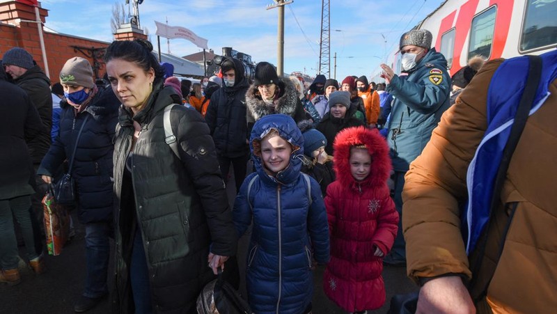 Orang-orang dari wilayah Donetsk dan Luhansk, wilayah yang dikuasai oleh pemerintah separatis pro-Rusia di Ukraina timur, berjalan kaki dari kereta api untuk dibawa ke tempat tinggal sementara di wilayah Volgograd, di stasiun kereta api di Volzhsky, wilayah Volgograd, Rusia, pada Minggu, 20 Februari 2022. (REUTERS/VLADIMIR LAVROV)
