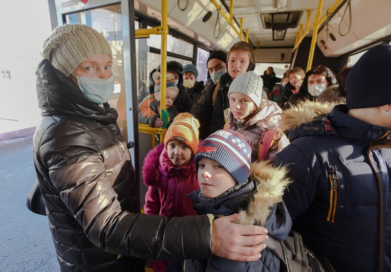 Orang-orang dari wilayah Donetsk dan Luhansk, wilayah yang dikuasai oleh pemerintah separatis pro-Rusia di Ukraina timur, berjalan kaki dari kereta api untuk dibawa ke tempat tinggal sementara di wilayah Volgograd, di stasiun kereta api di Volzhsky, wilayah Volgograd, Rusia, pada Minggu, 20 Februari 2022. (REUTERS/VLADIMIR LAVROV)