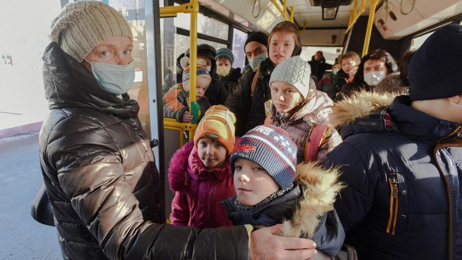 Orang-orang dari wilayah Donetsk dan Luhansk, wilayah yang dikuasai oleh pemerintah separatis pro-Rusia di Ukraina timur, berjalan kaki dari kereta api untuk dibawa ke tempat tinggal sementara di wilayah Volgograd, di stasiun kereta api di Volzhsky, wilayah Volgograd, Rusia, pada Minggu, 20 Februari 2022. (REUTERS/VLADIMIR LAVROV)